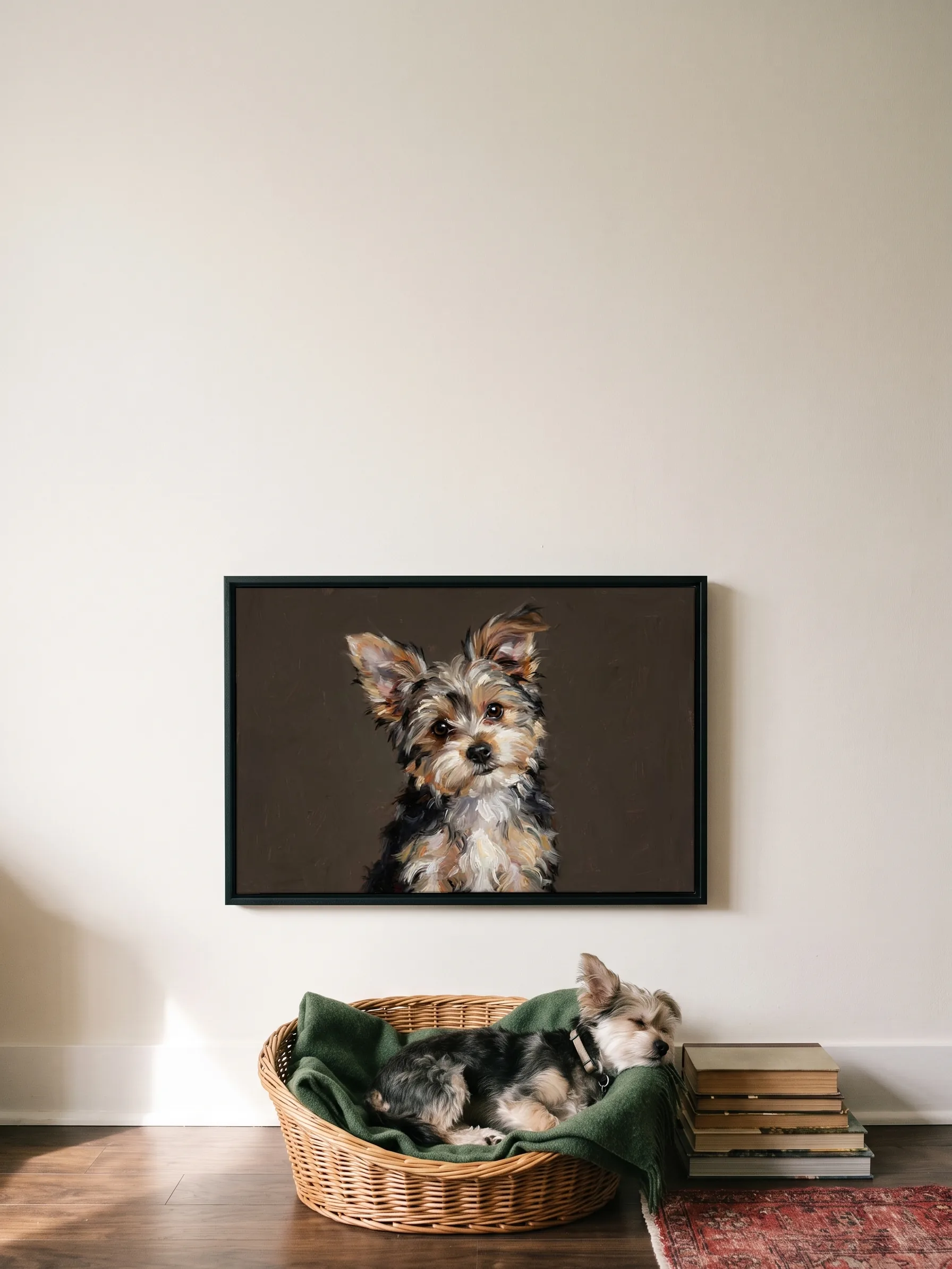 A Yorkshire terrier cross asleep in its basket under its own oil painting, a framed canvas on the wall