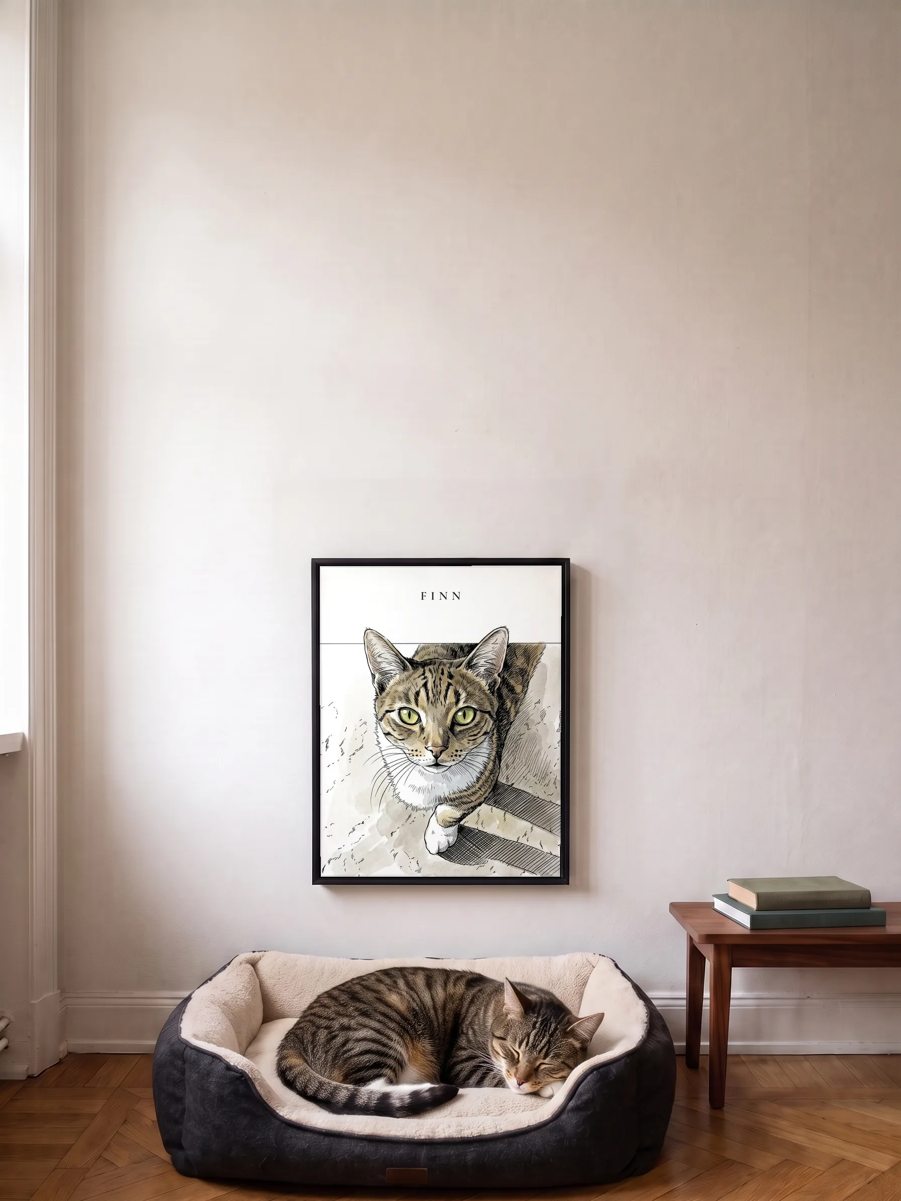 A tabby cat asleep in a big dog bed under its own ink portrait, a framed canvas on the wall