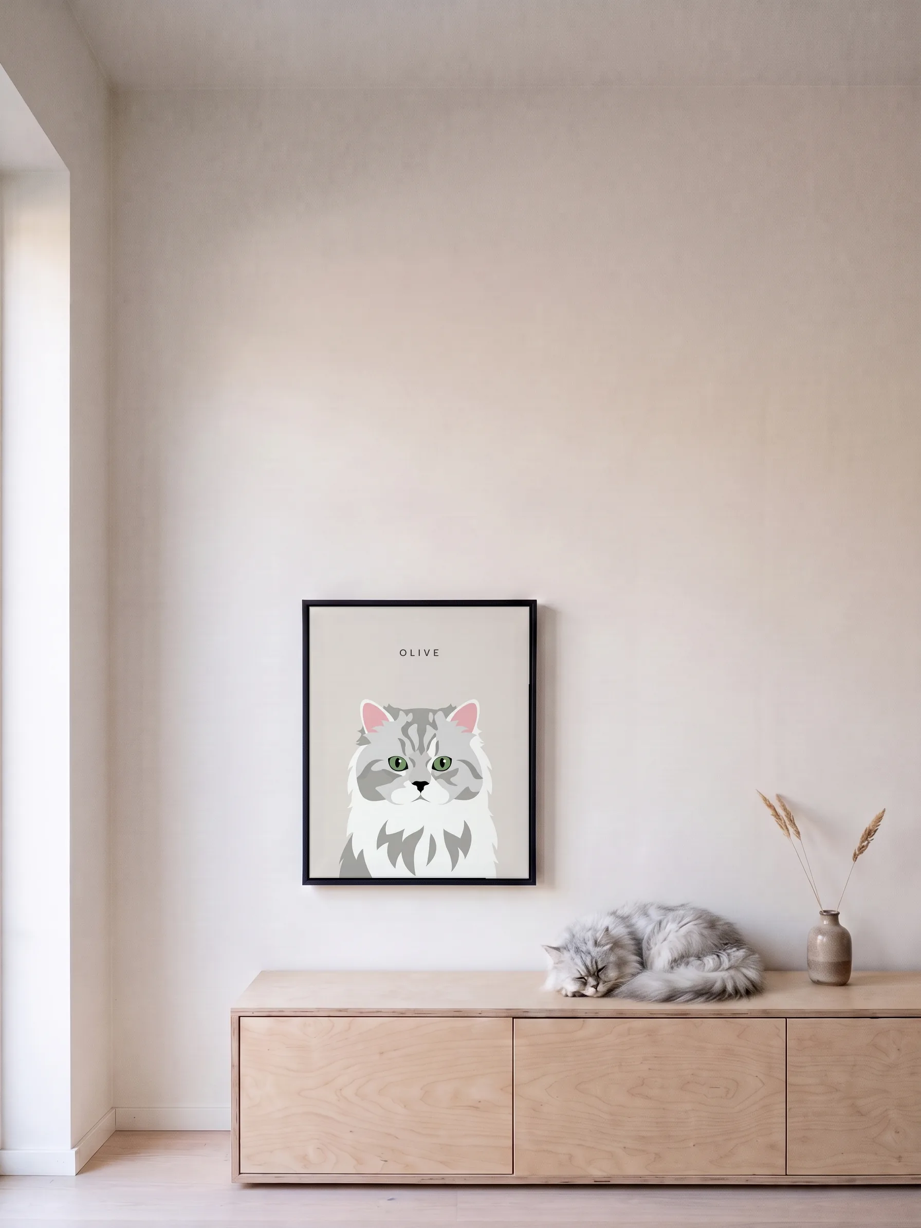 A silver Persian cat asleep on a birch sideboard under its own minimalist portrait, a framed canvas on the wall