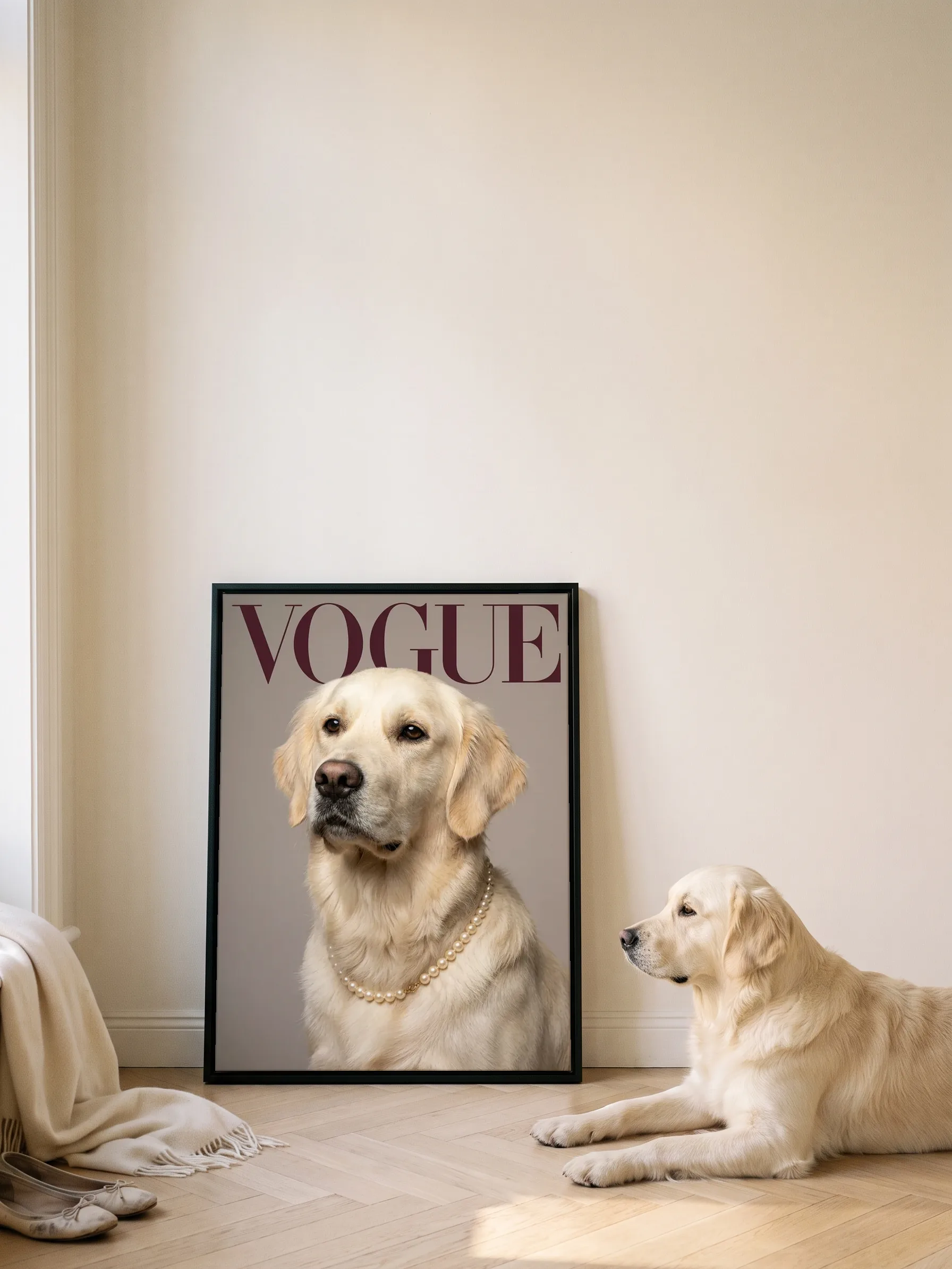 A golden retriever lying in profile beside its own cover portrait: a canvas in a slim black frame leaning on a wall, sun on the parquet