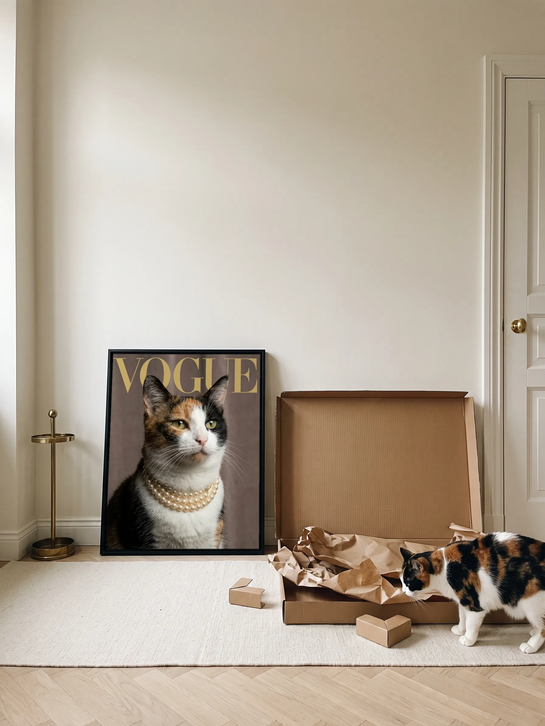 A calico cat nosing the paper in the open carton its framed canvas portrait came in; the portrait leans on the wall by the front door