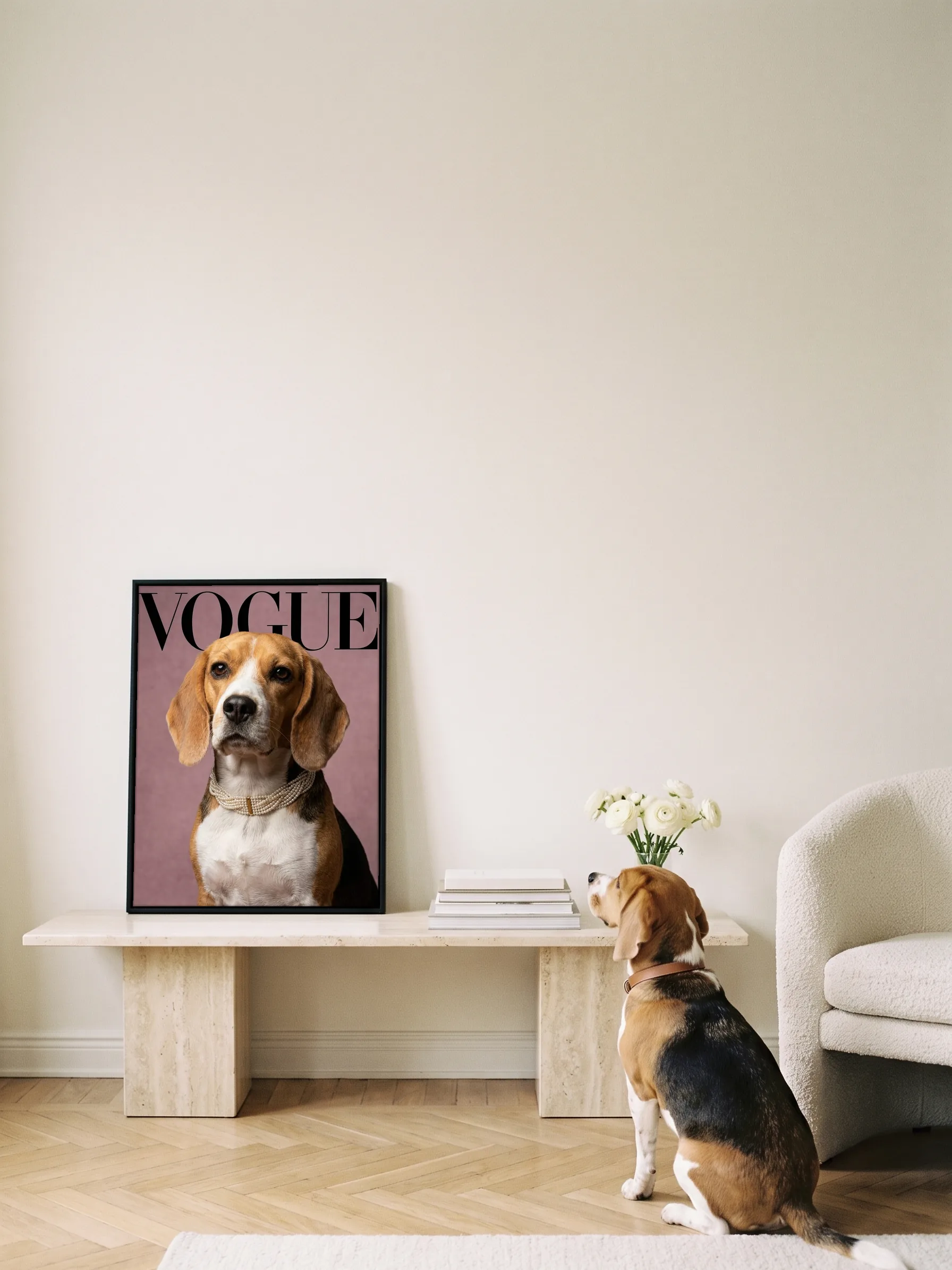 A beagle sitting on oak parquet, seen from behind, looking up at its own cover portrait: a framed canvas on a travertine console