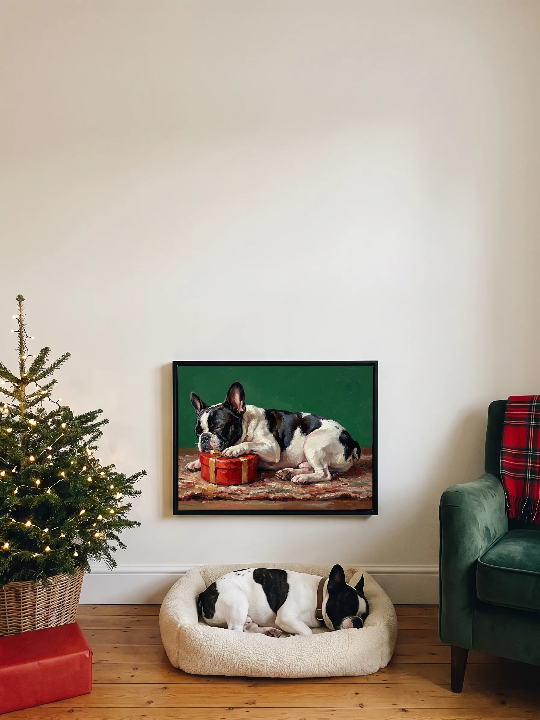 A black and white French bulldog asleep in its bed under its own oil painting, a wide framed canvas on the wall, a small Christmas tree beside it